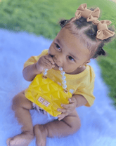 Toddler girl is wearing a set of two handmade hair clips for little girls from By Bella Boutique.